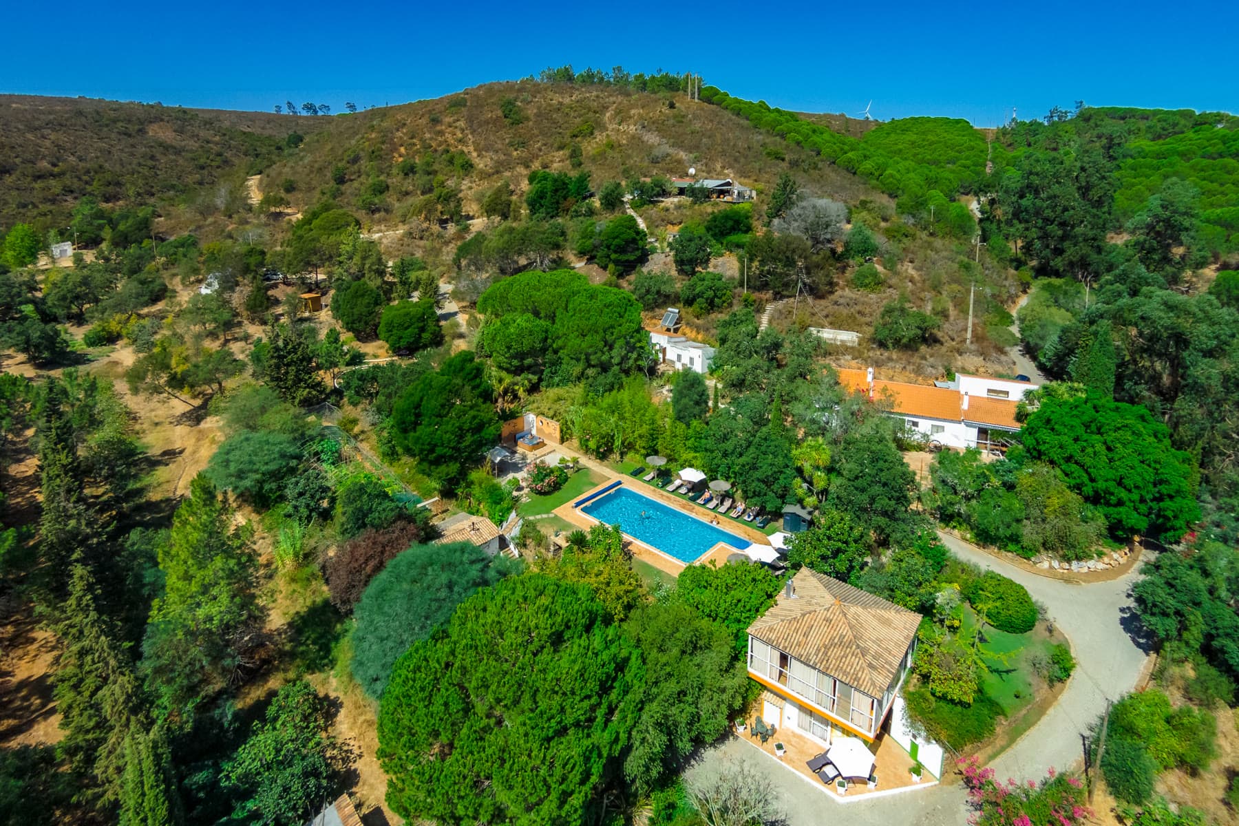 Aerial view of Moinhos Velhos — pool, gardens and buildings folded into the pines
